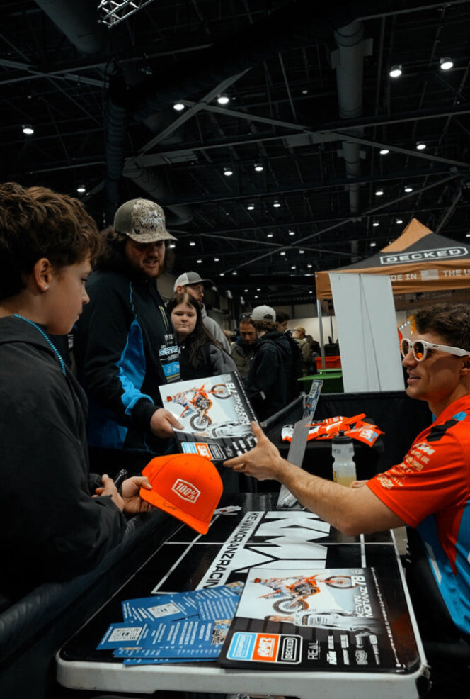 Kevin Moranz signing autographs at a convention or event with a table full of items.