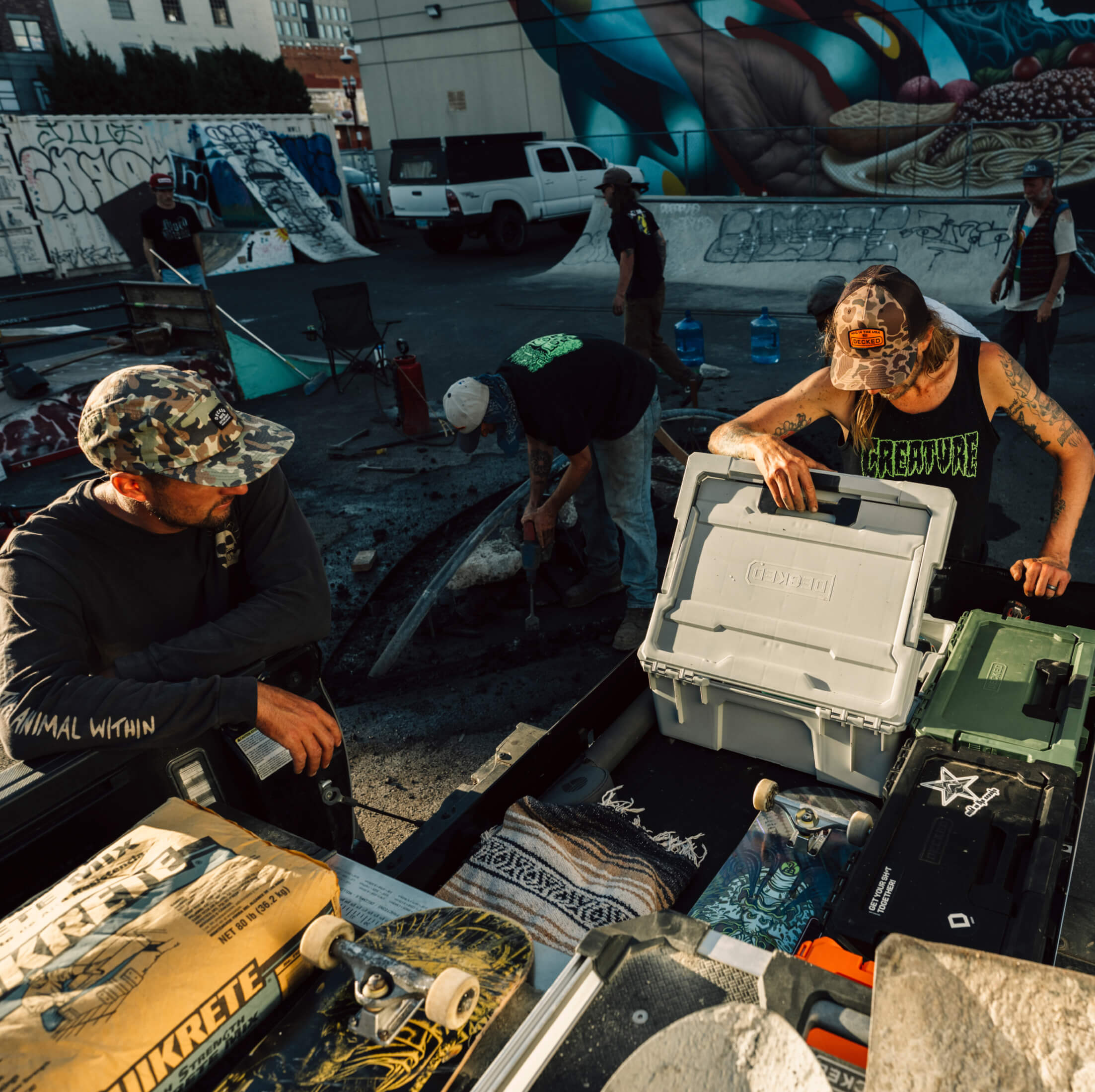 Skateboarders at a skate park with skateboards and coolers.
