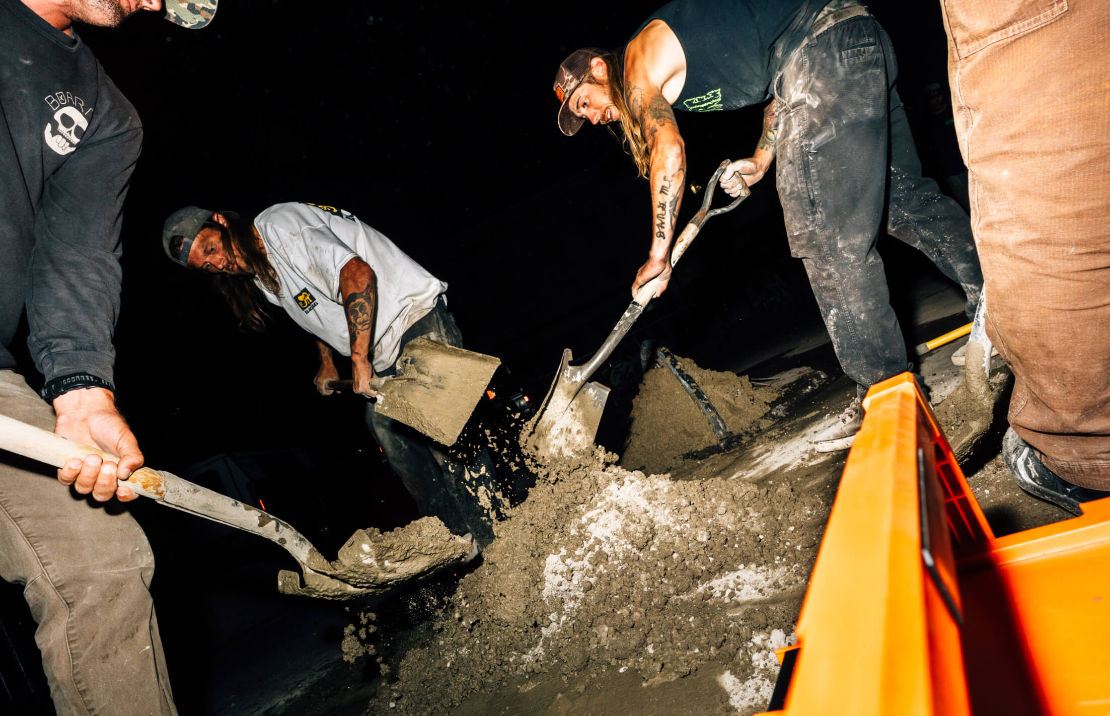 People using shovels to dig in a dark setting