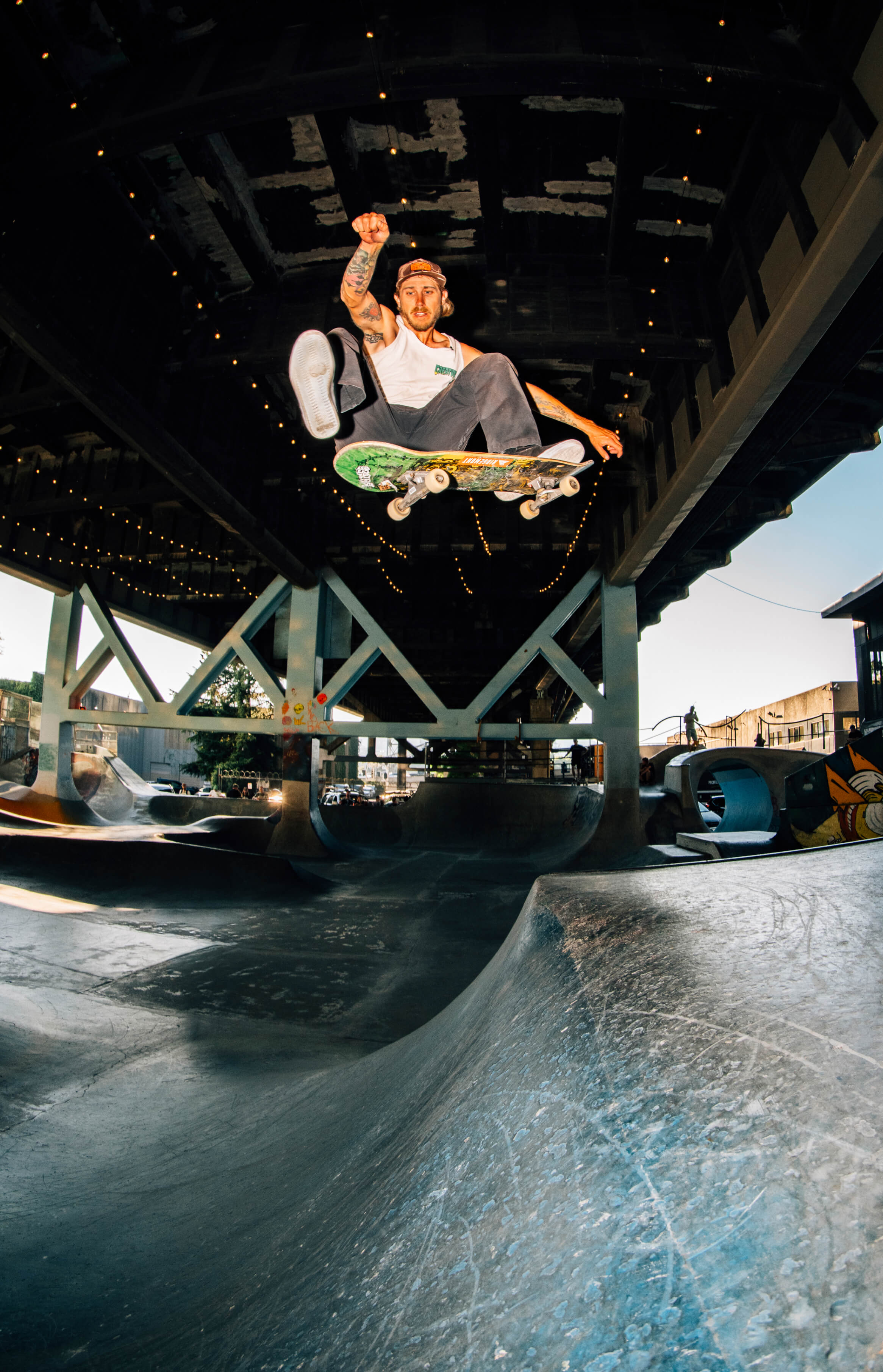 Skateboarder performing a trick under a bridge