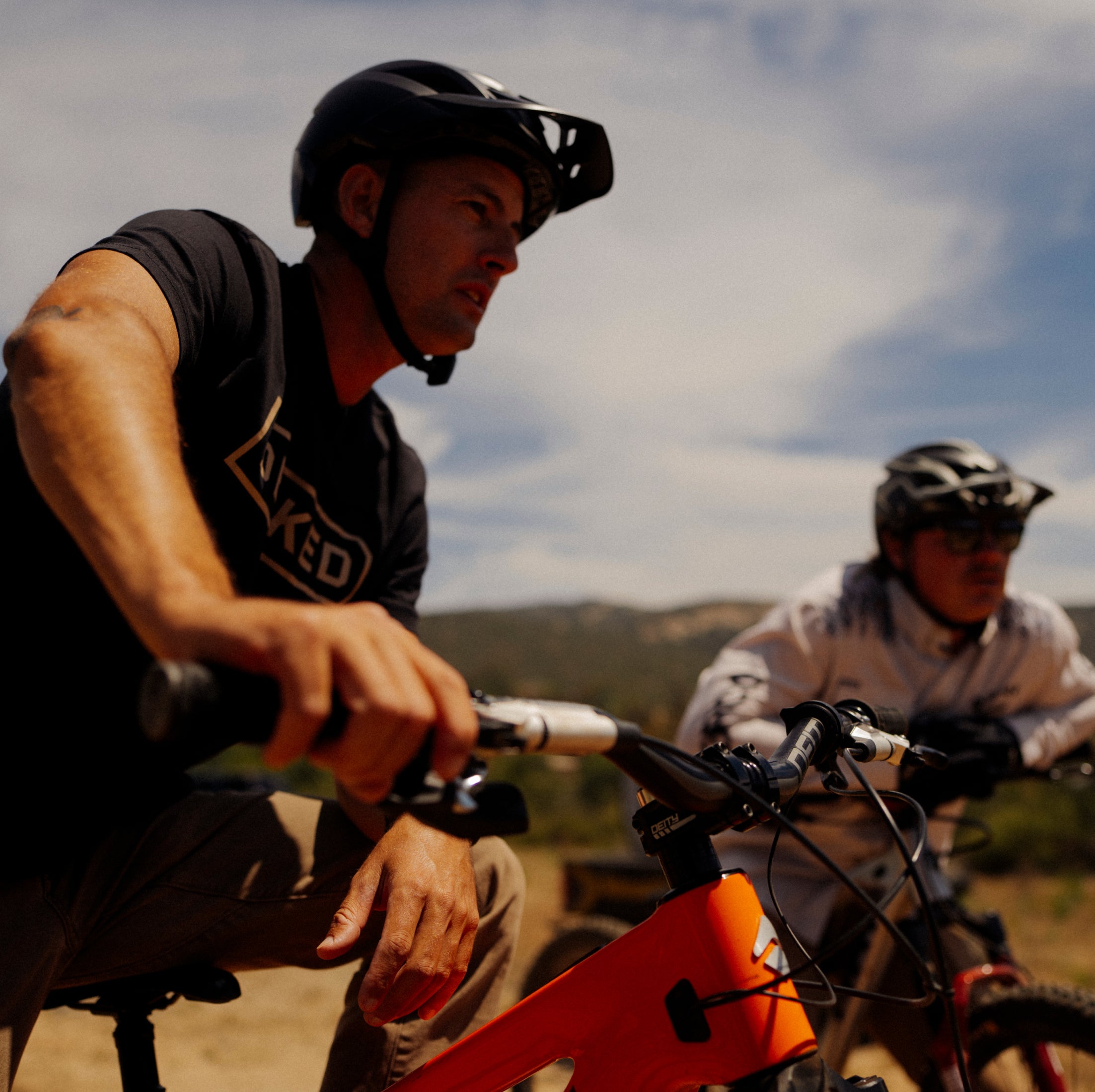 Danny Bolton and Kyle Strait on mountain bikes with a scenic background