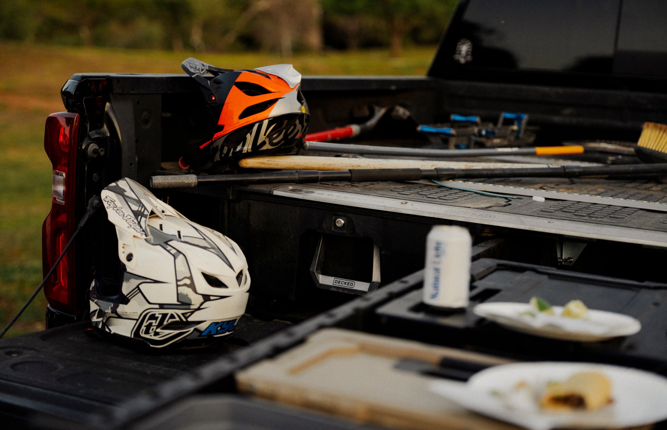 Motorcycle helmets and tools in a truck bed with a blurred background