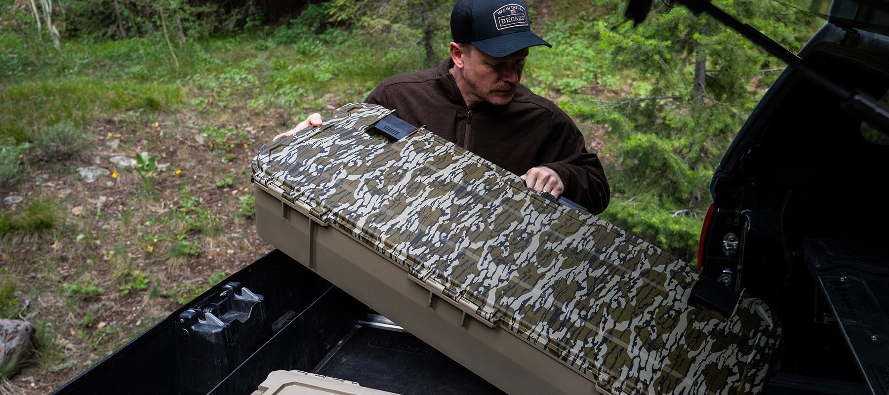 A man loading a Mossy Oak Honcho into his DECKED Drawer System.