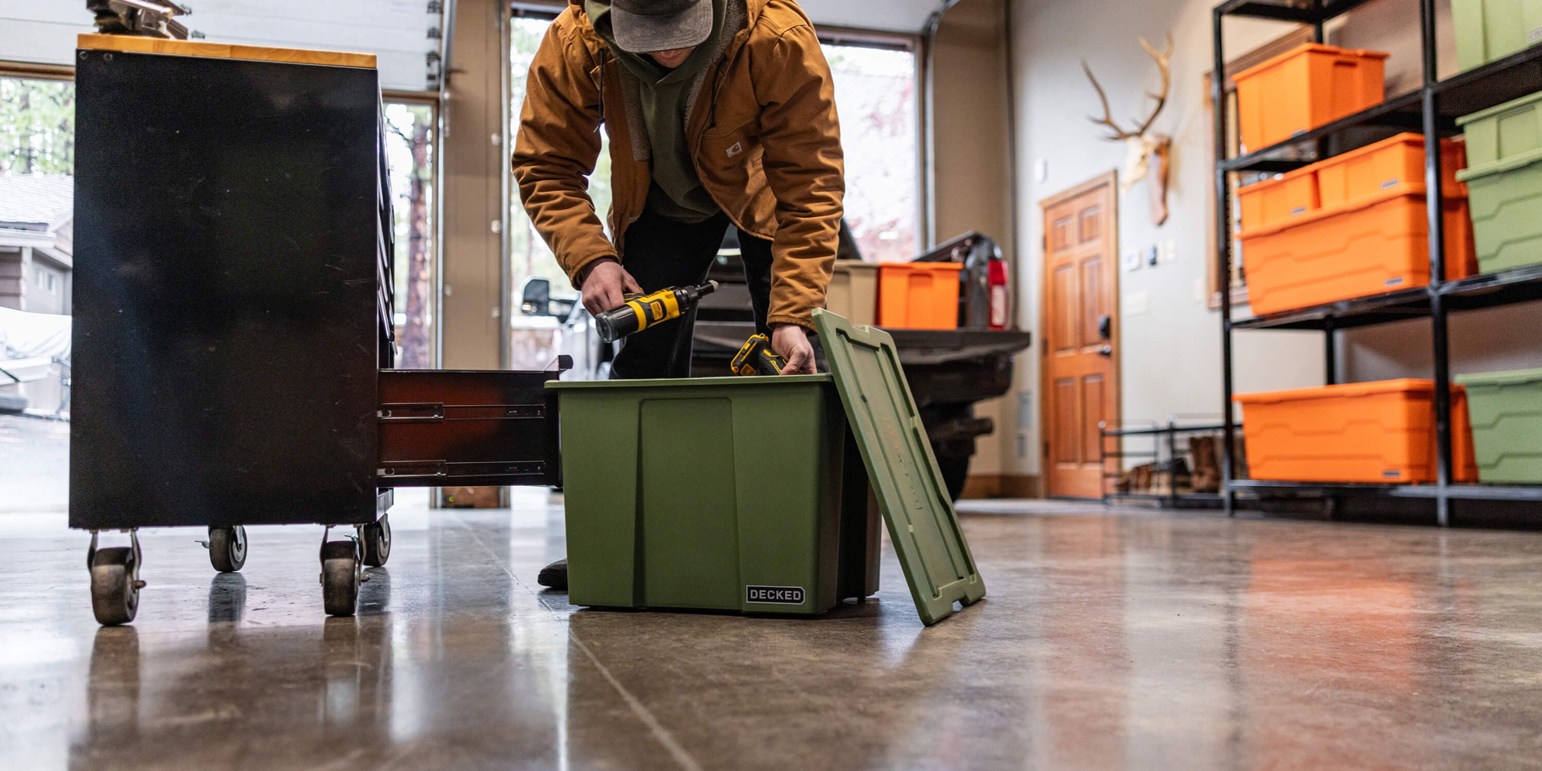 A man loading power tools in a ranger green Payloader 64 in his garage.