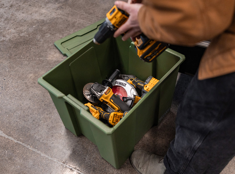 Person organizing tools in a green Payloader 64.