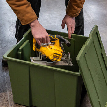 Person placing a yellow power tool into a green Payloader 64 bin.