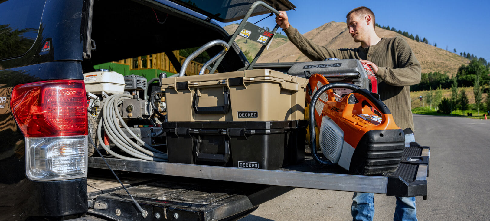 A man retrieving a generator off of his CargoGlide that is full of D-co Cases and other equipment.