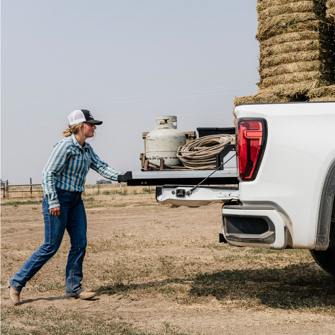 A woman rancher retrieving ropes from her CargoGlide system as she prepares to brand her cattle.