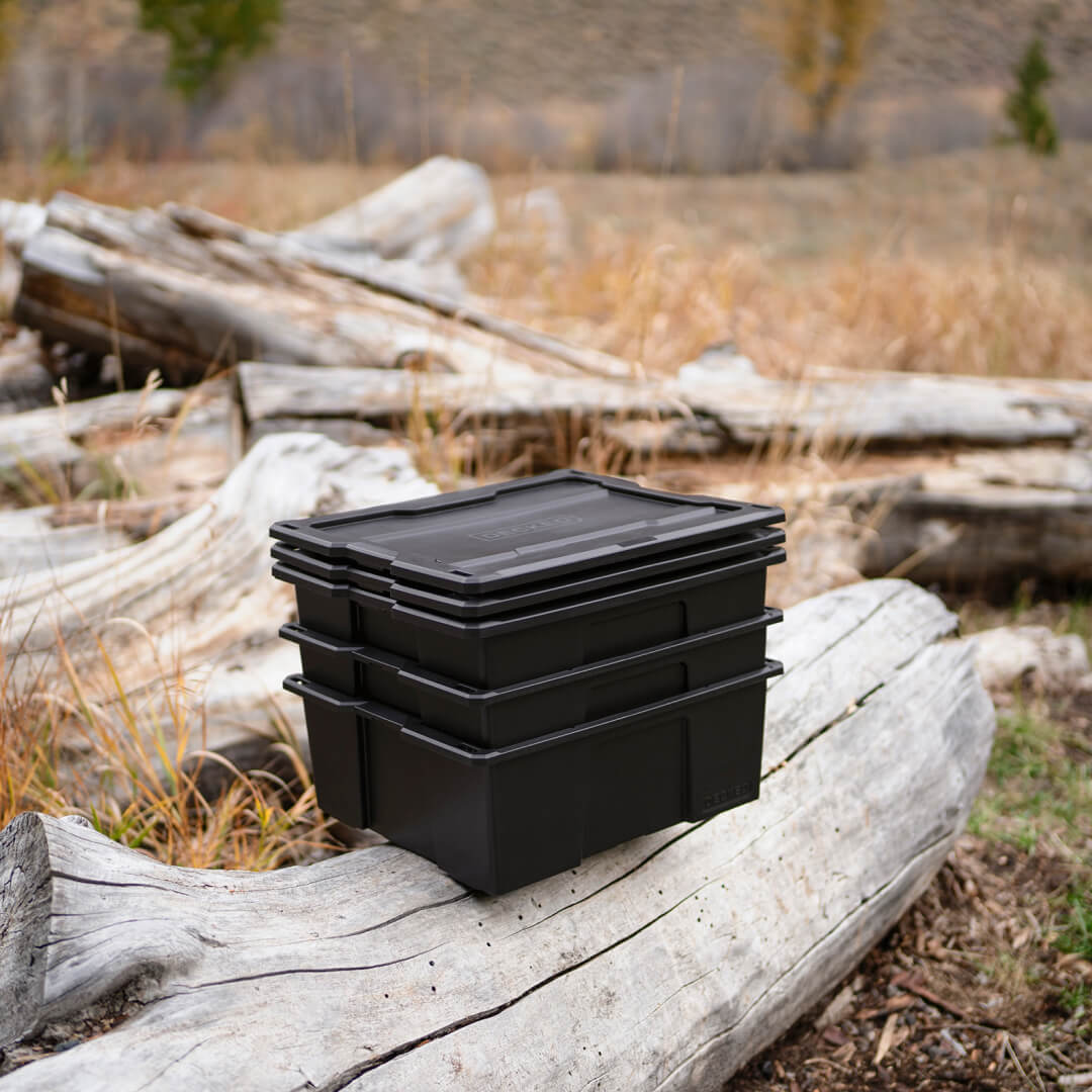 3 Black D-co bins stacked sitting on a log