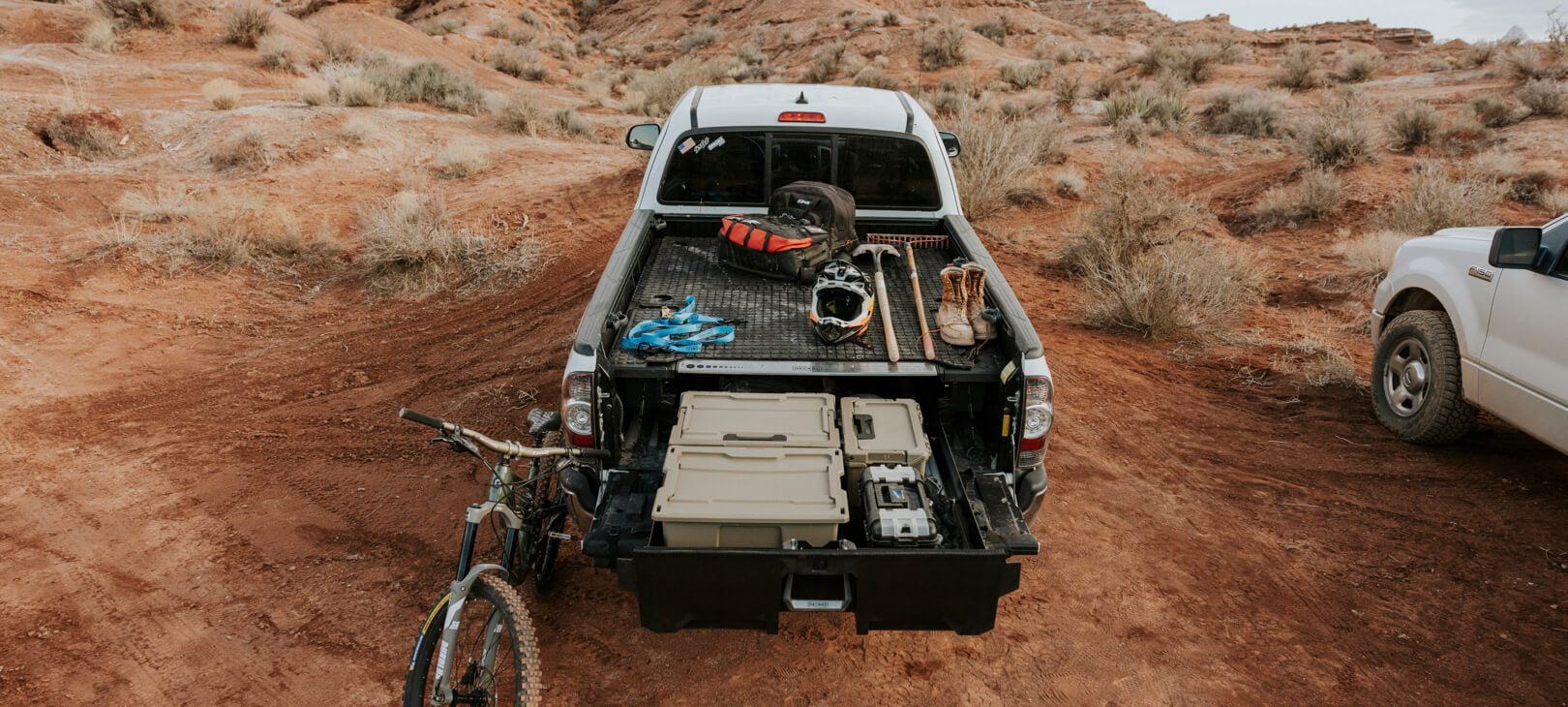 A battle mat on a Drawer System out in the desert, piled high with biking gear.