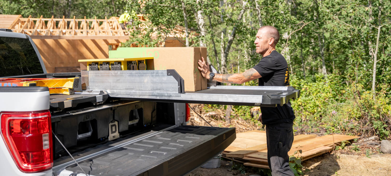 A man loading boxes onto his Half Width CargoGlide with High Sides.