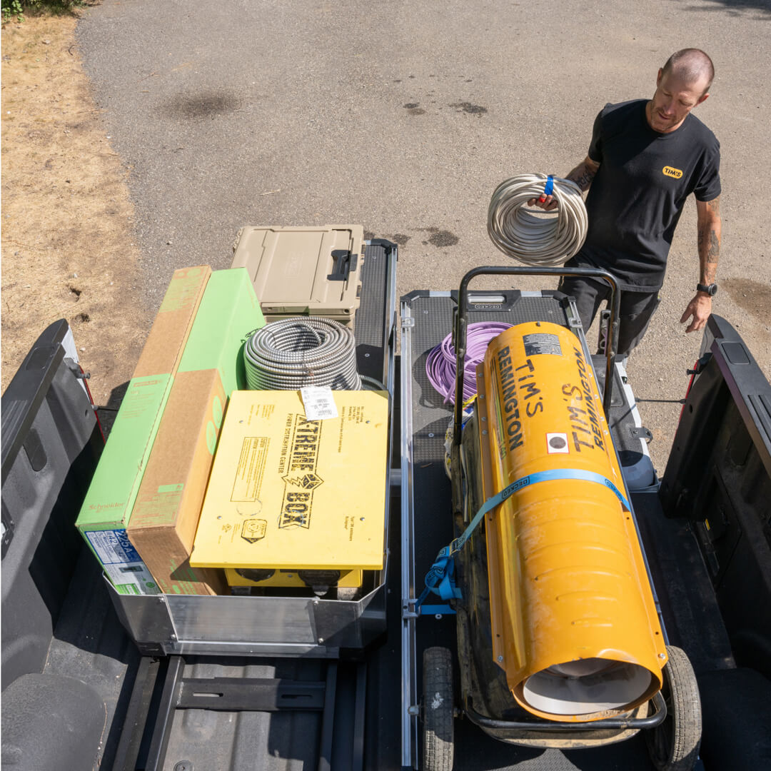 An electrician loading gear onto his CargoGlide with high sides.