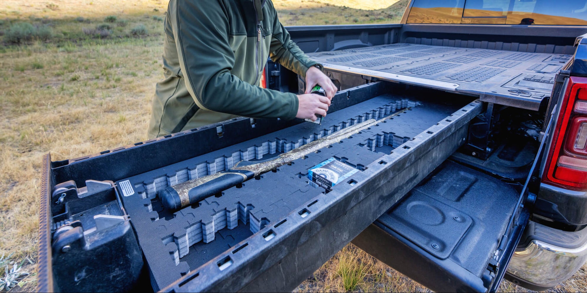 A man organizing his bird hunting gear, including his shotgun and shells, in his Drawer System Piecekeeper PuzzleFoam.