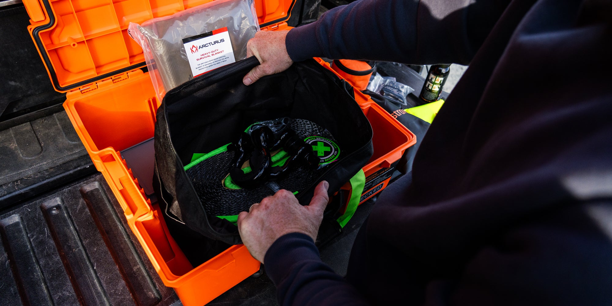 Someone retrieving the tow straps out of the Roadside OS Kit.