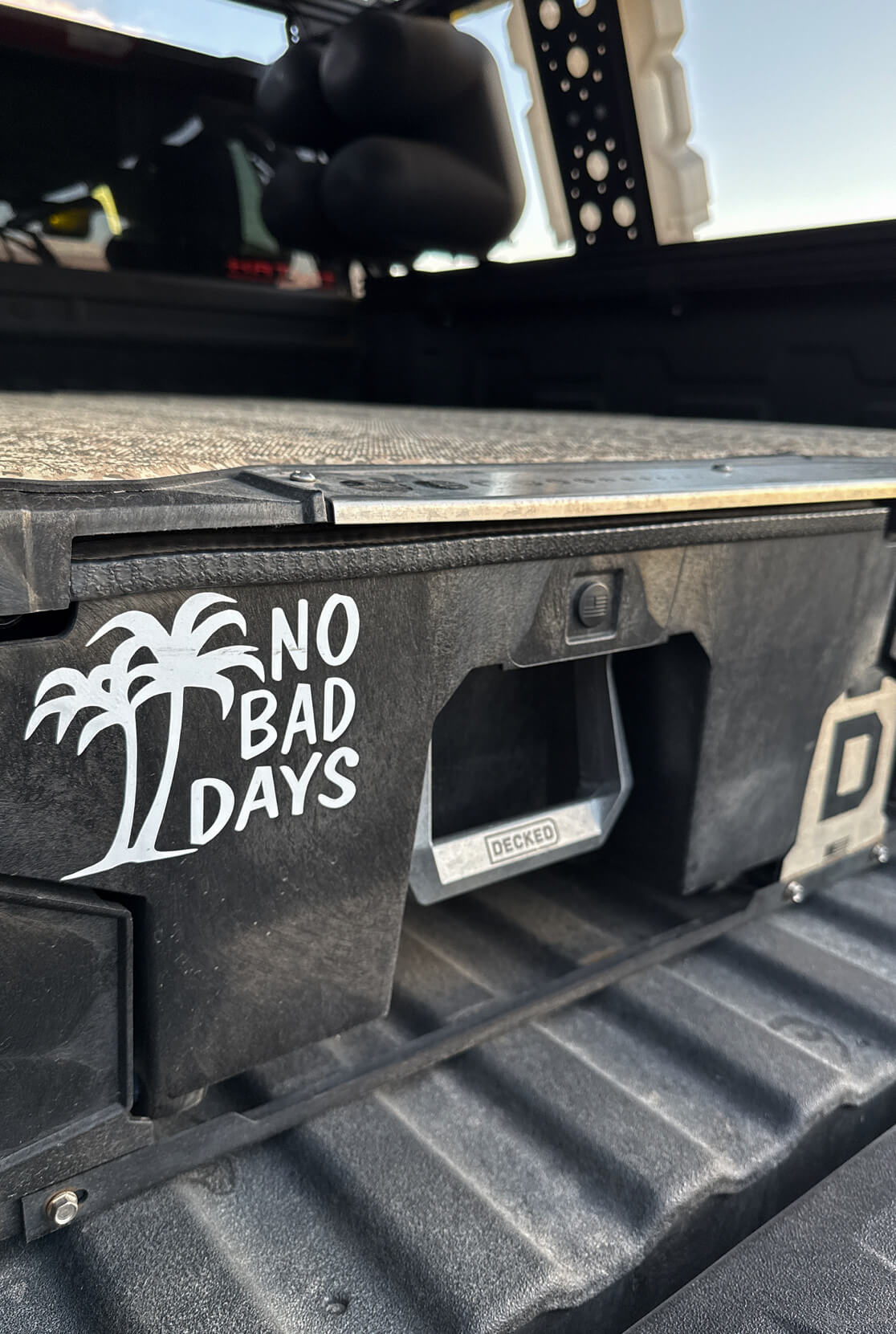 Truck bed with 'No Bad Days' decal and palm tree design.