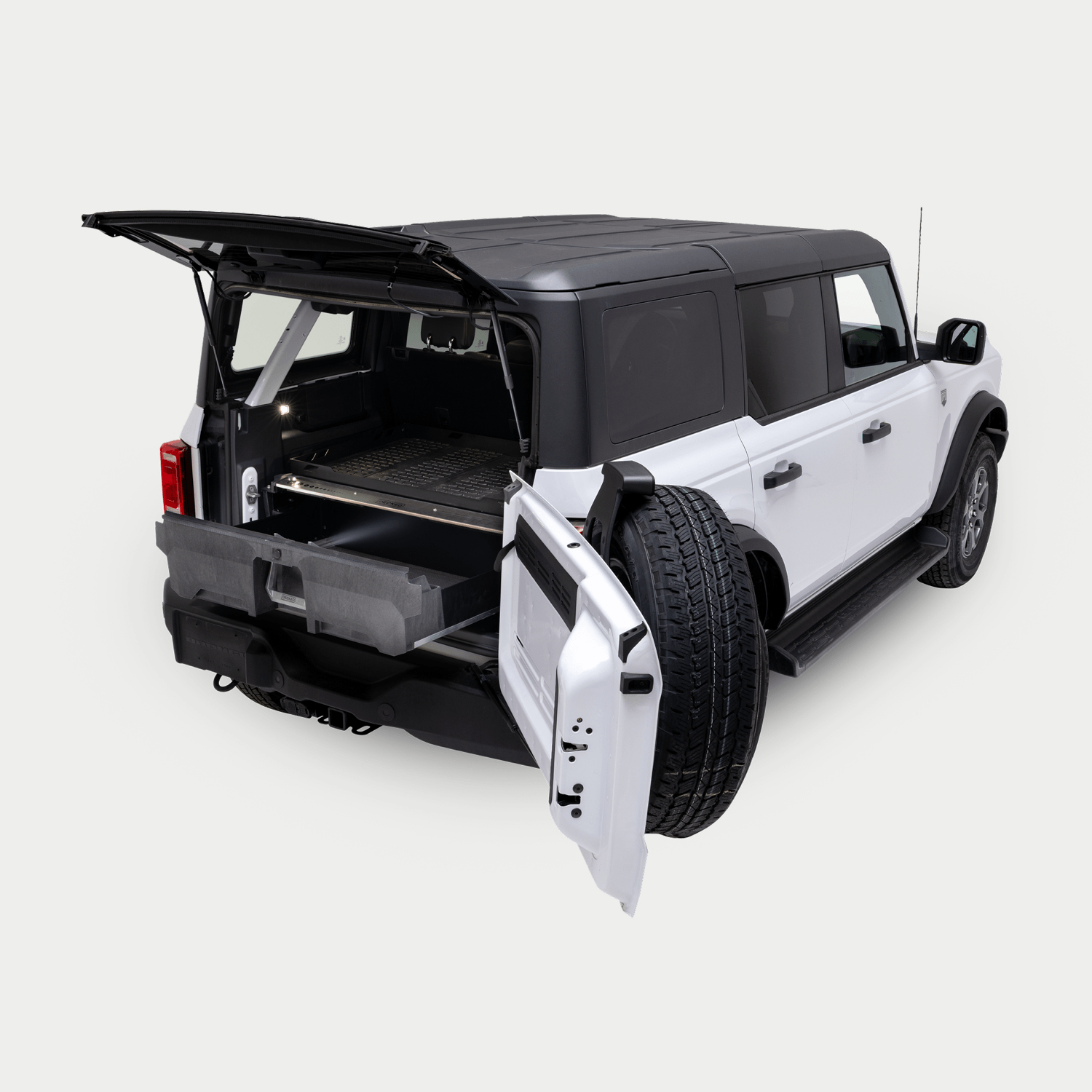 A white 4-Door Ford Bronco on a white background with a Drawer System installed in the cargo area. The Drawer System is extended and shows the interior storage space.