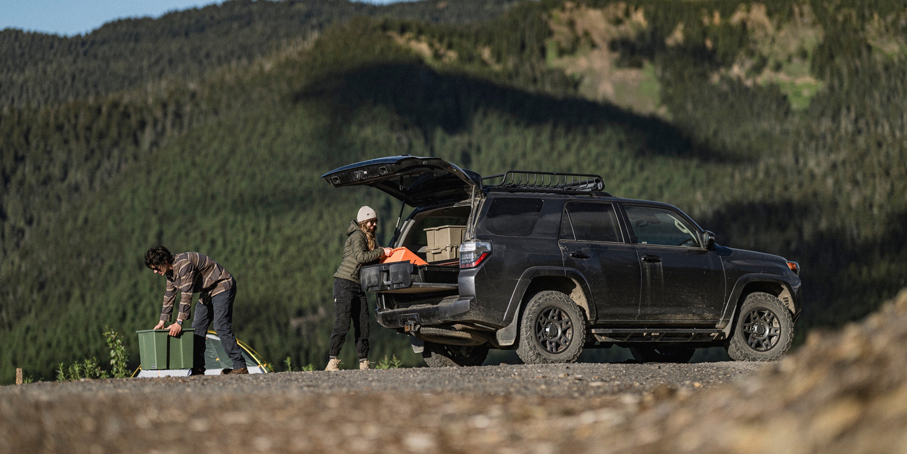 Two people unloading the camping gear that they had stored inside of their Drawer System in their 4Runner.