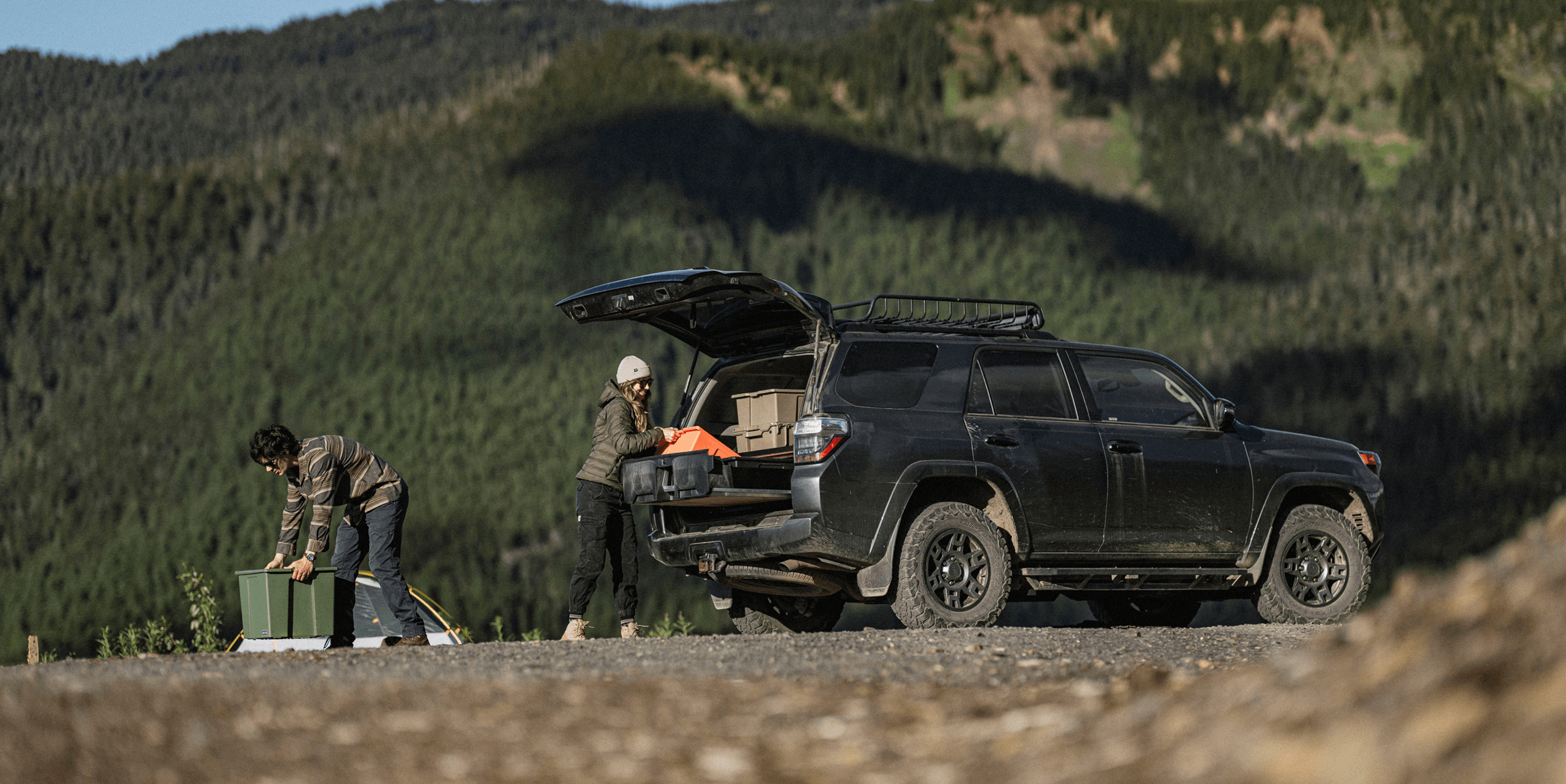 Two people unloading the camping gear that they had stored inside of their Drawer System in their 4Runner.
