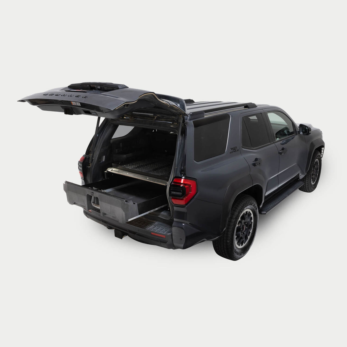 A Grey 6th Generation Toyota 4Runner on a white background with a Drawer System installed in the cargo area. The Drawer System is extended and shows the interior storage space.