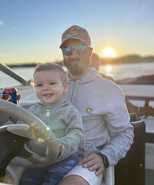 Man driving a boat with a young boy
