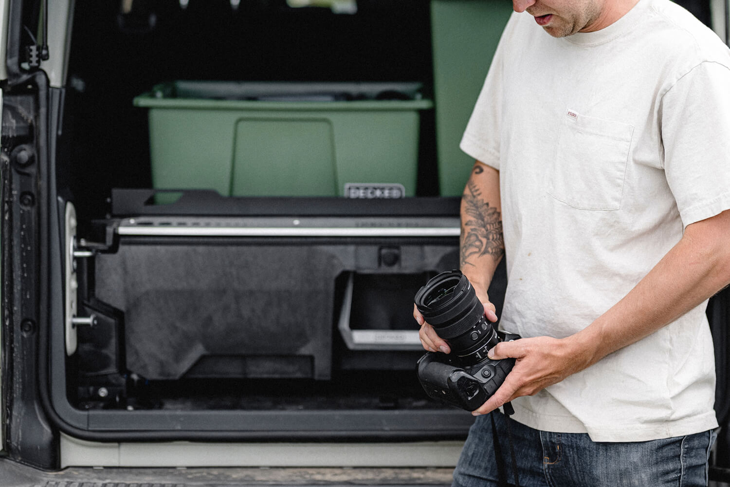 Man loads his nice camera in the back of his locked and secure DECKED drawer system.