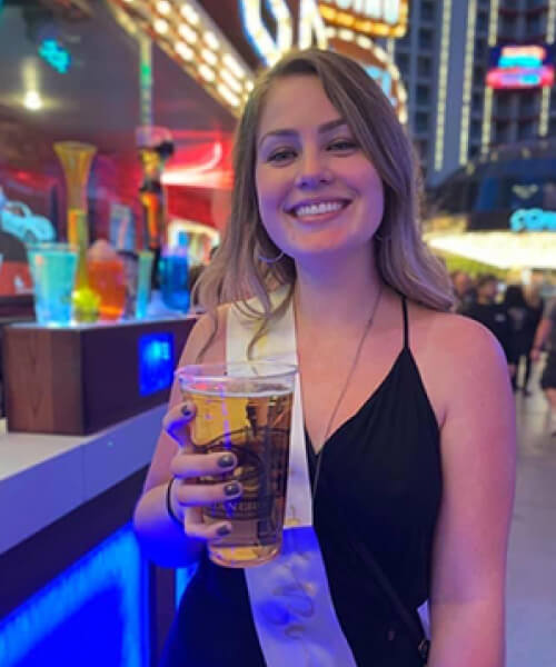 Woman smiling holding a large beer