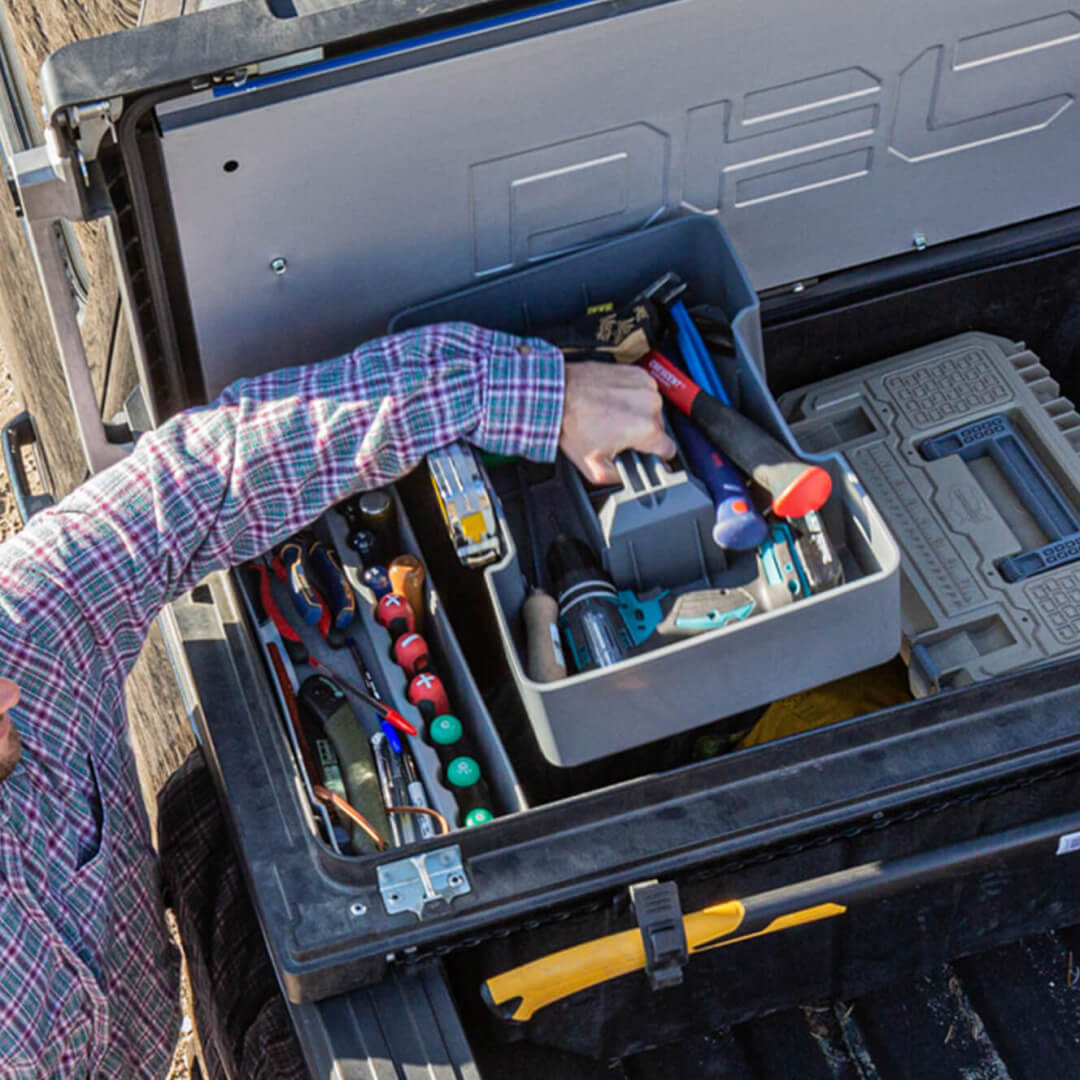 Man Grabbing a Tool Box Tray filled with tools out of his DECKED Tool Box