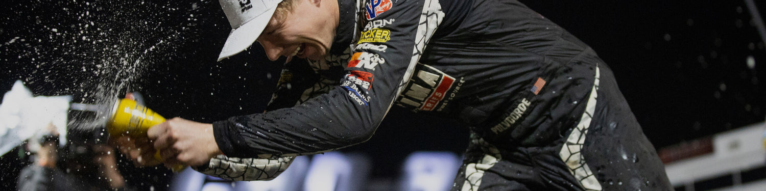 Chris Polvoorde after winning a race, showing the crowd around the podium in beer.