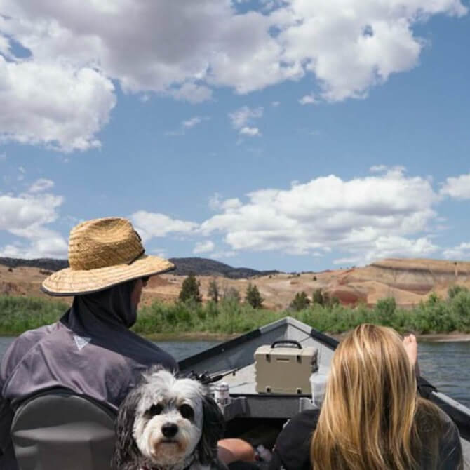 Two people in a boat on a lake with a scenic background