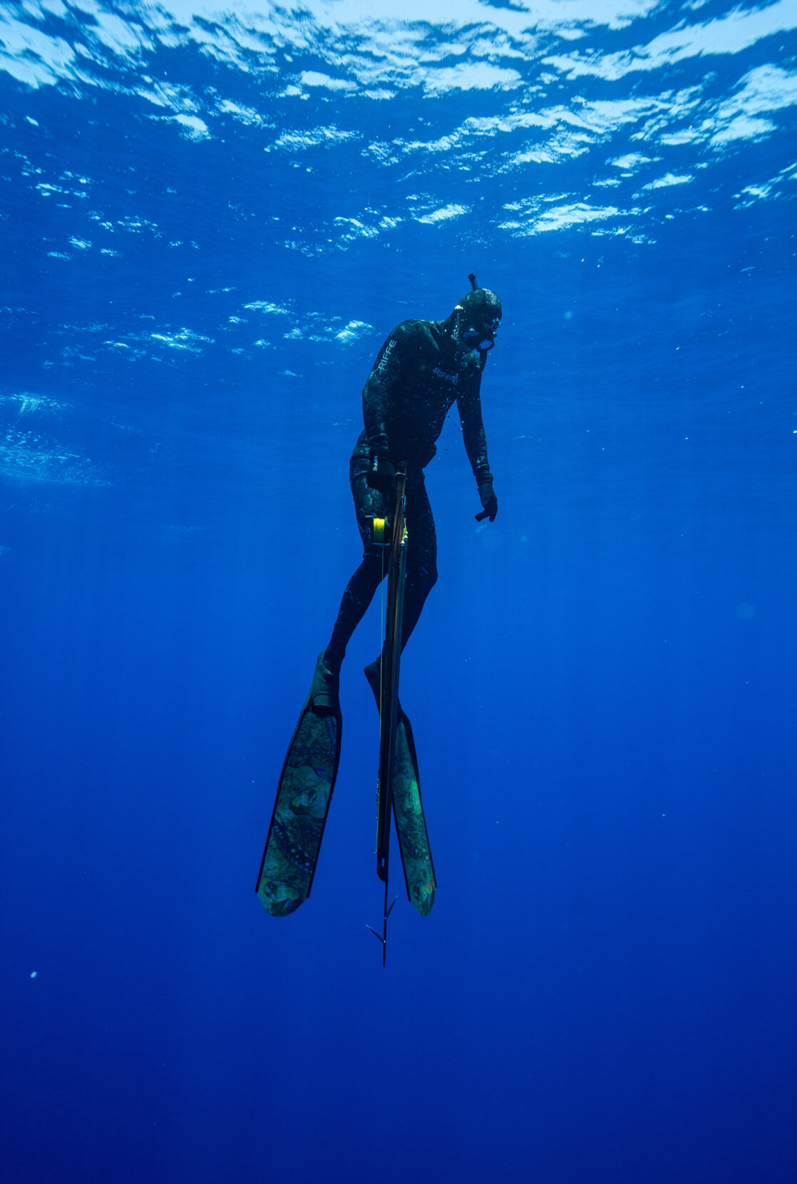 Danny Bolton floating ethereally in the big blue, fully equipped with his wetsuit, snorkel, fins, and speargun.