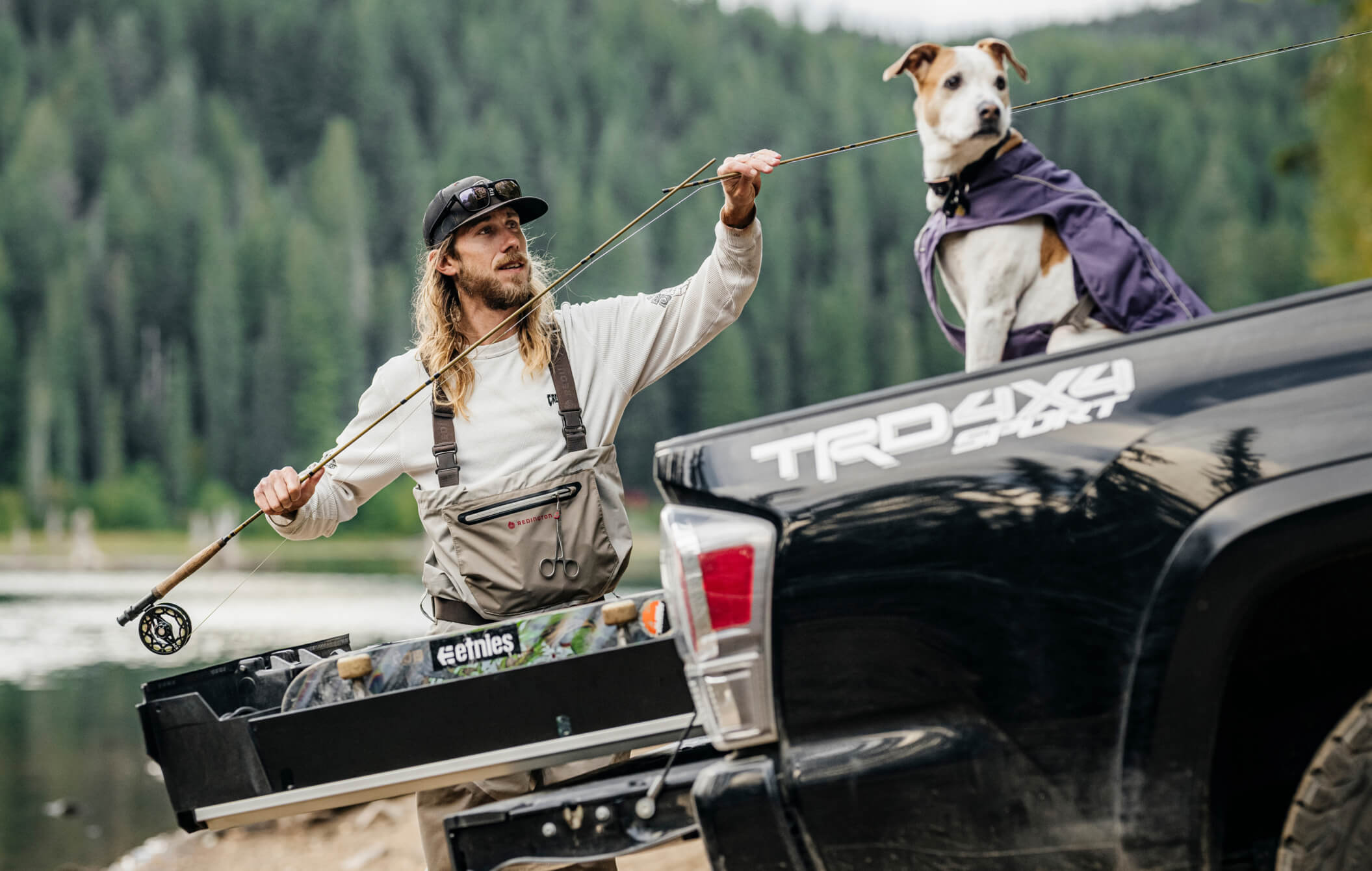 David Gravette rigging up his flyrod that he stores in his Drawer System with his loyal pup sitting nearby.