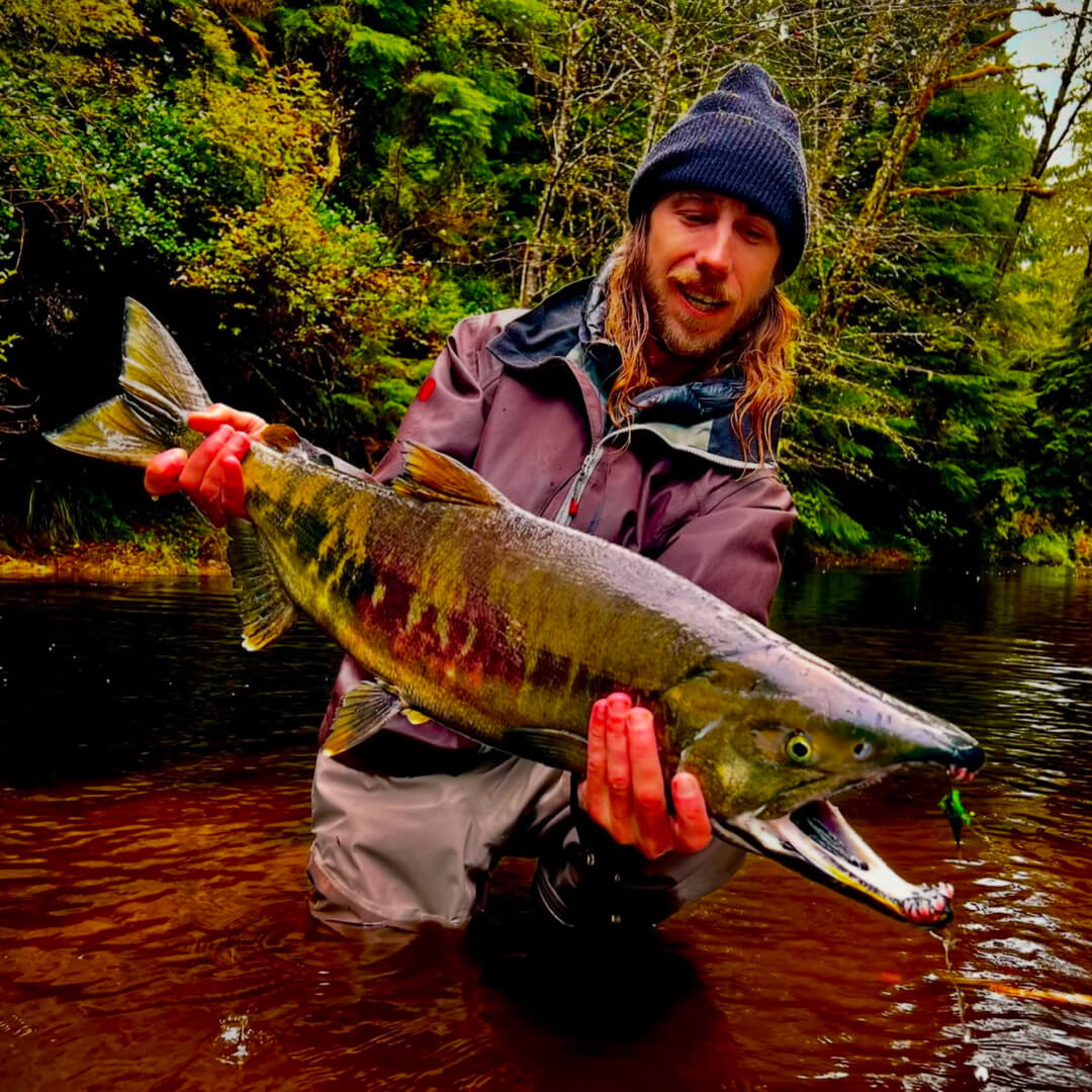 David Gravette holding onto a salmon he caught on the fly.