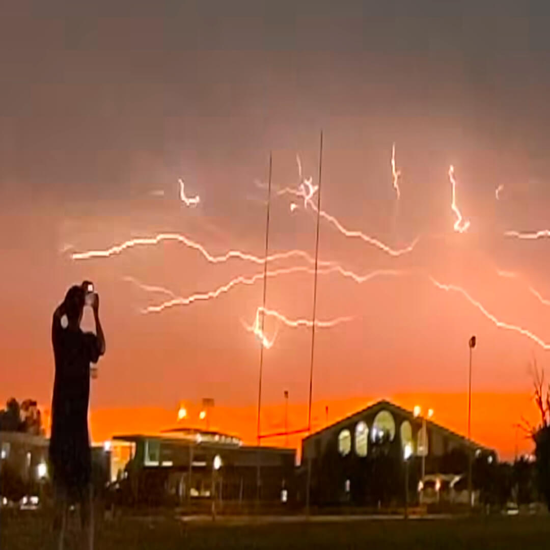 A field being lit up by a web of lightning.