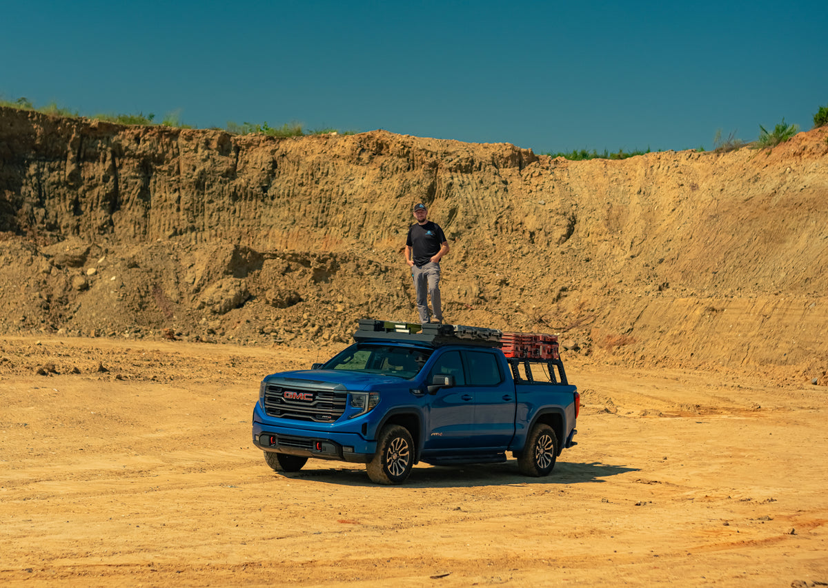 Thor Rippet standing on top of his GMC on a dirt worksite.