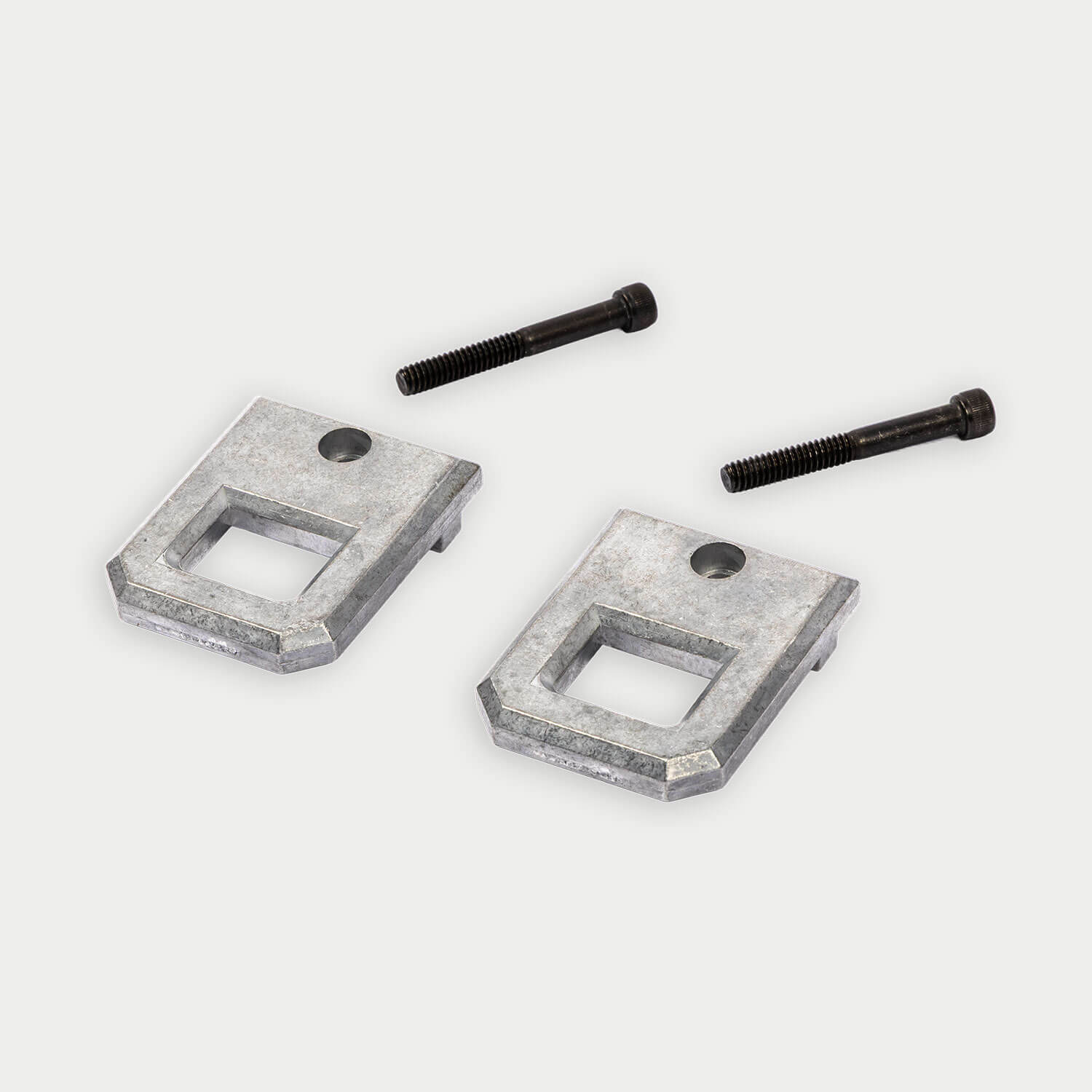 Two metal brackets and two screws on a white background