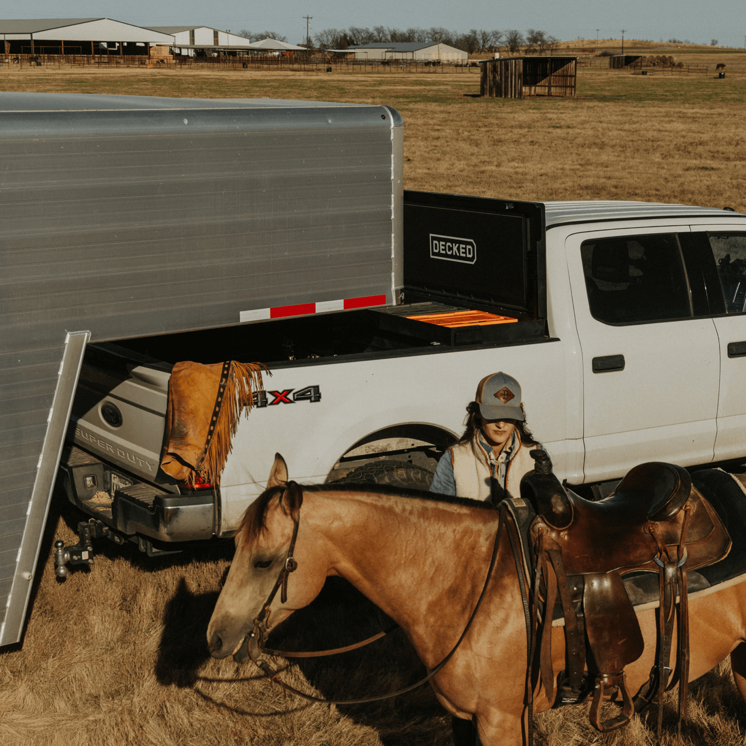 Person with a horse and a truck with a DECKED Tool Box and gooseneck trailer in a rural setting