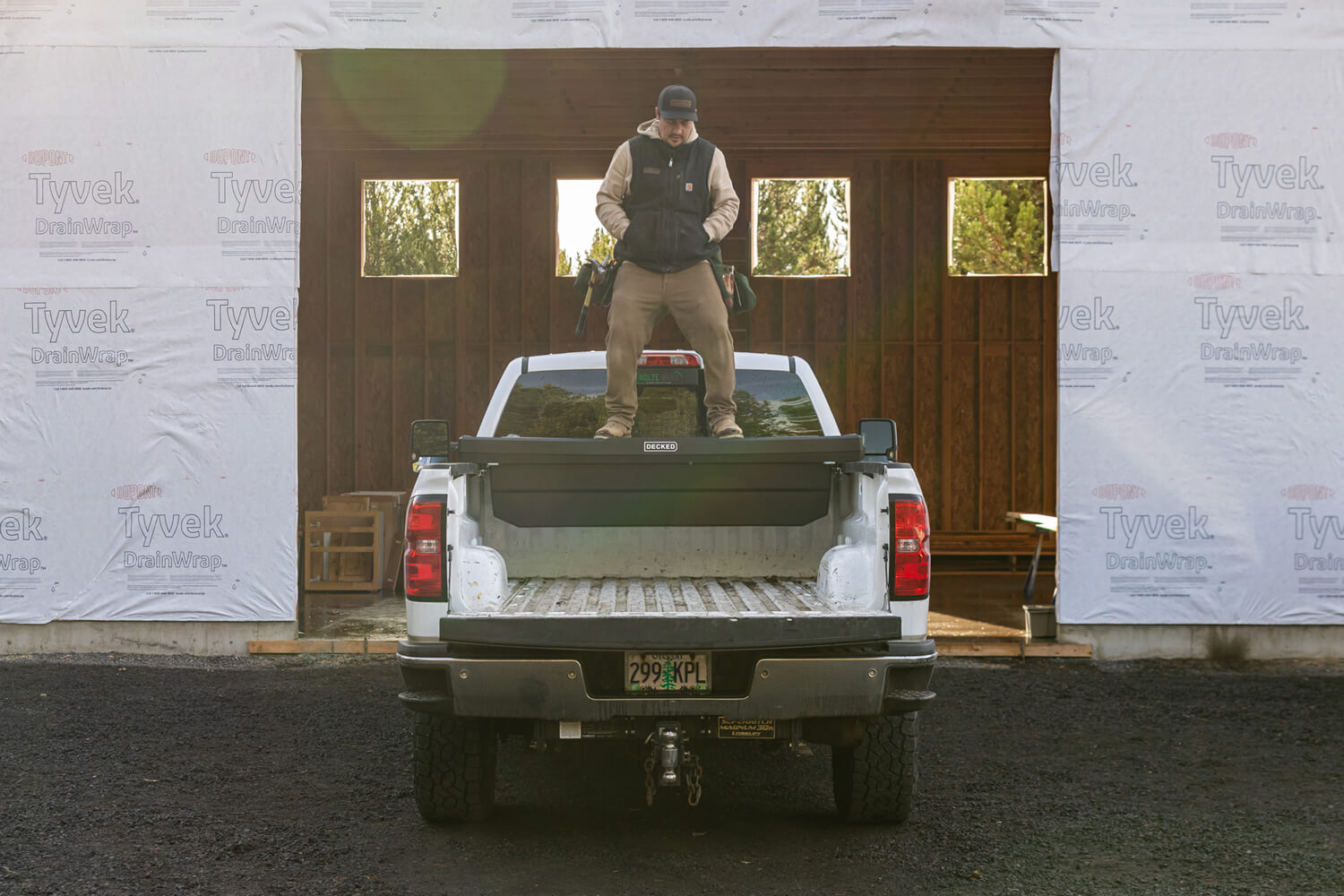 Person jumping on top of a DECKED Tool Box installed in a white pickup truck to show how durable and strong the lid of the Tool Box is.